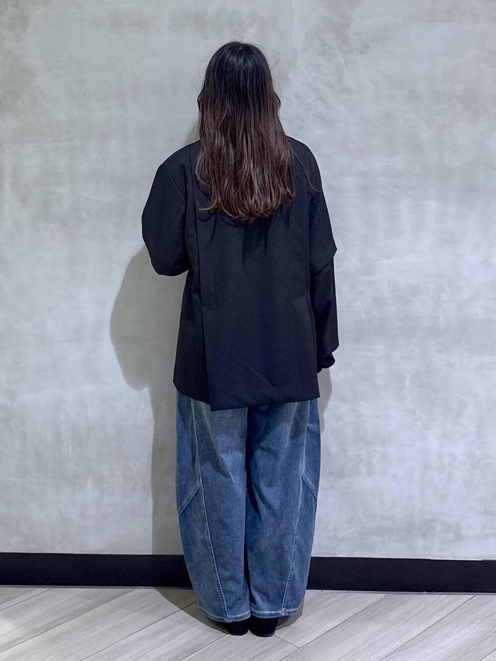 ブラック系のテーラードジャケット、ブルー系のデニムパンツ、ブラック系のモカシン/デッキシューズを着用したレディースの春コーディネートの5枚目の写真