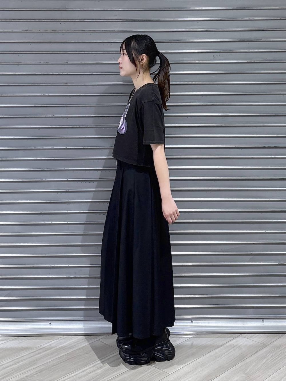 グレー系のTシャツ/カットソー、ブラック系のブーツ、ブラック系のスカートを着用したレディースの夏コーディネートの3枚目の写真