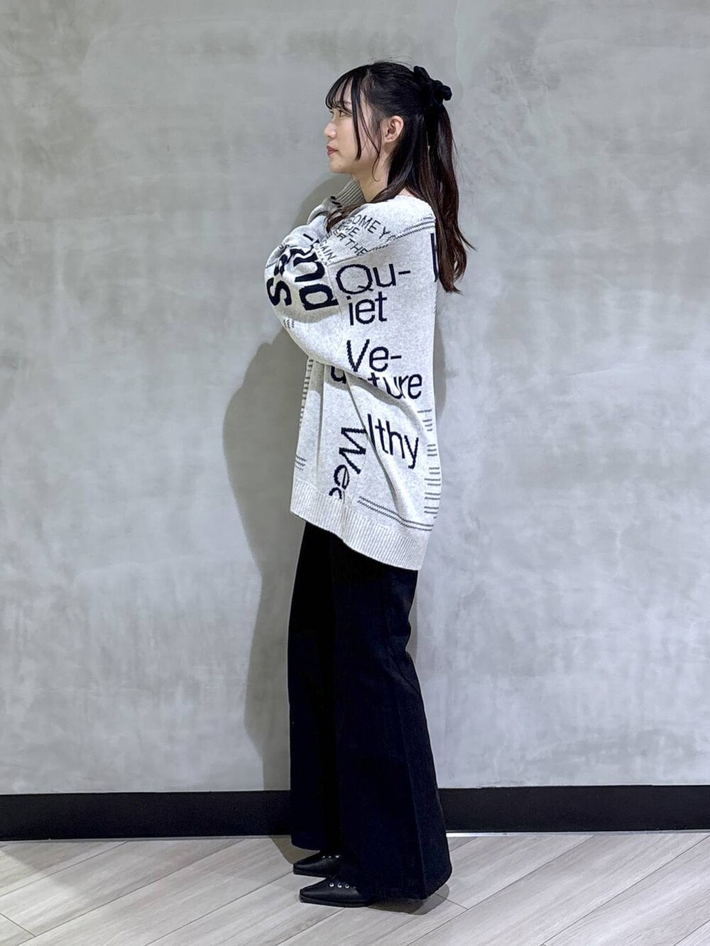 ブルー系のデニムパンツ、ブラック系のサンダル、グレー系のニット/セーターを着用したレディースの冬コーディネートの3枚目の写真