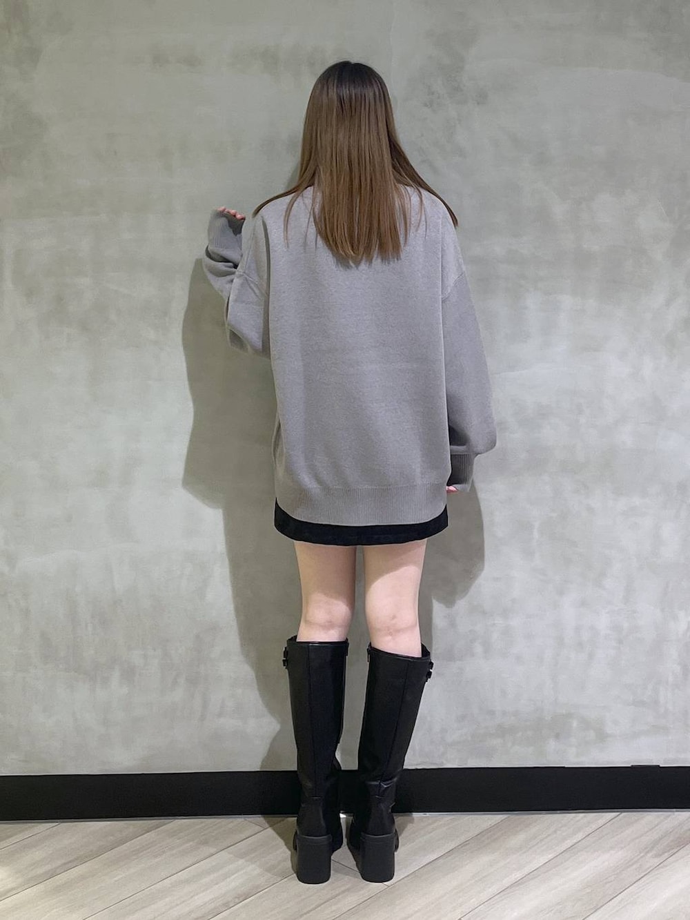 ブラック系のブーツ、ブラック系のスカート、グレー系のニット/セーターを着用したレディースの秋コーディネートの6枚目の写真