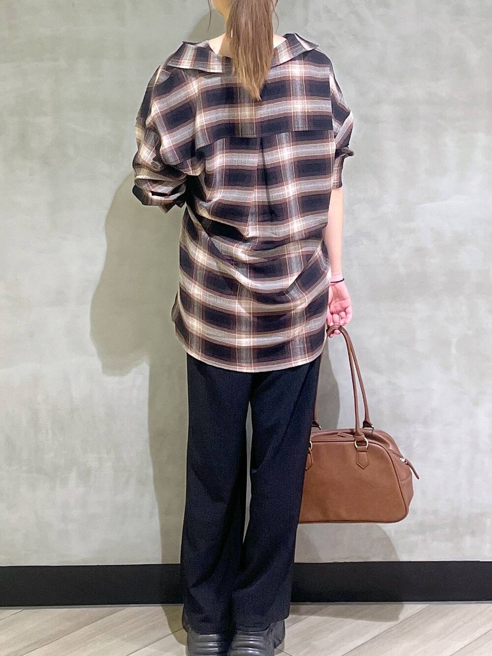 ブラック系のスニーカー、ブラック系のスラックス、ブラウン系のシャツ/ブラウスを着用したレディースの秋コーディネートの7枚目の写真