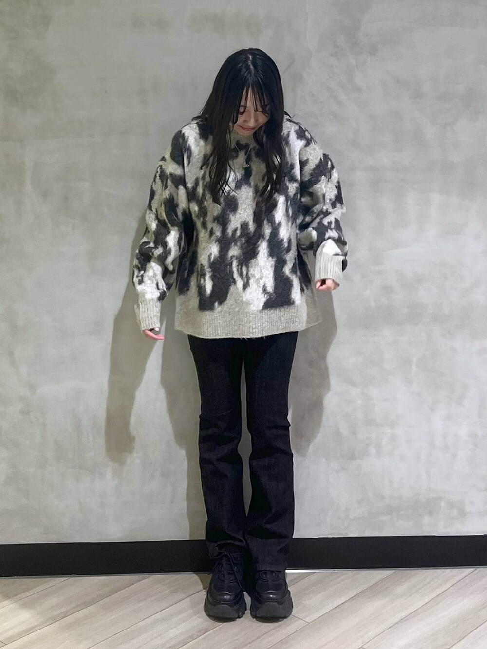 ブラック系のスニーカー、グレー系のニット/セーターを着用したレディースの秋コーディネートの2枚目の写真