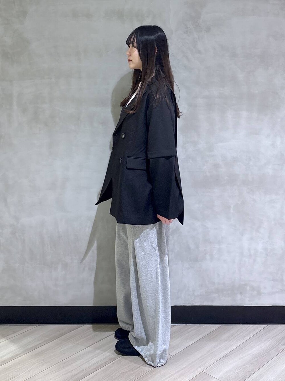 グレー系のスウェットパンツ、ブラック系のテーラードジャケット、ブラック系のモカシン/デッキシューズを着用したレディースの春コーディネートの3枚目の写真