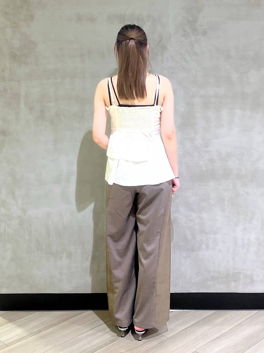 ホワイト系のパンプス、ブラウン系のスラックス、ホワイト系のキャミソールを着用したレディースの夏コーディネートの5枚目の写真