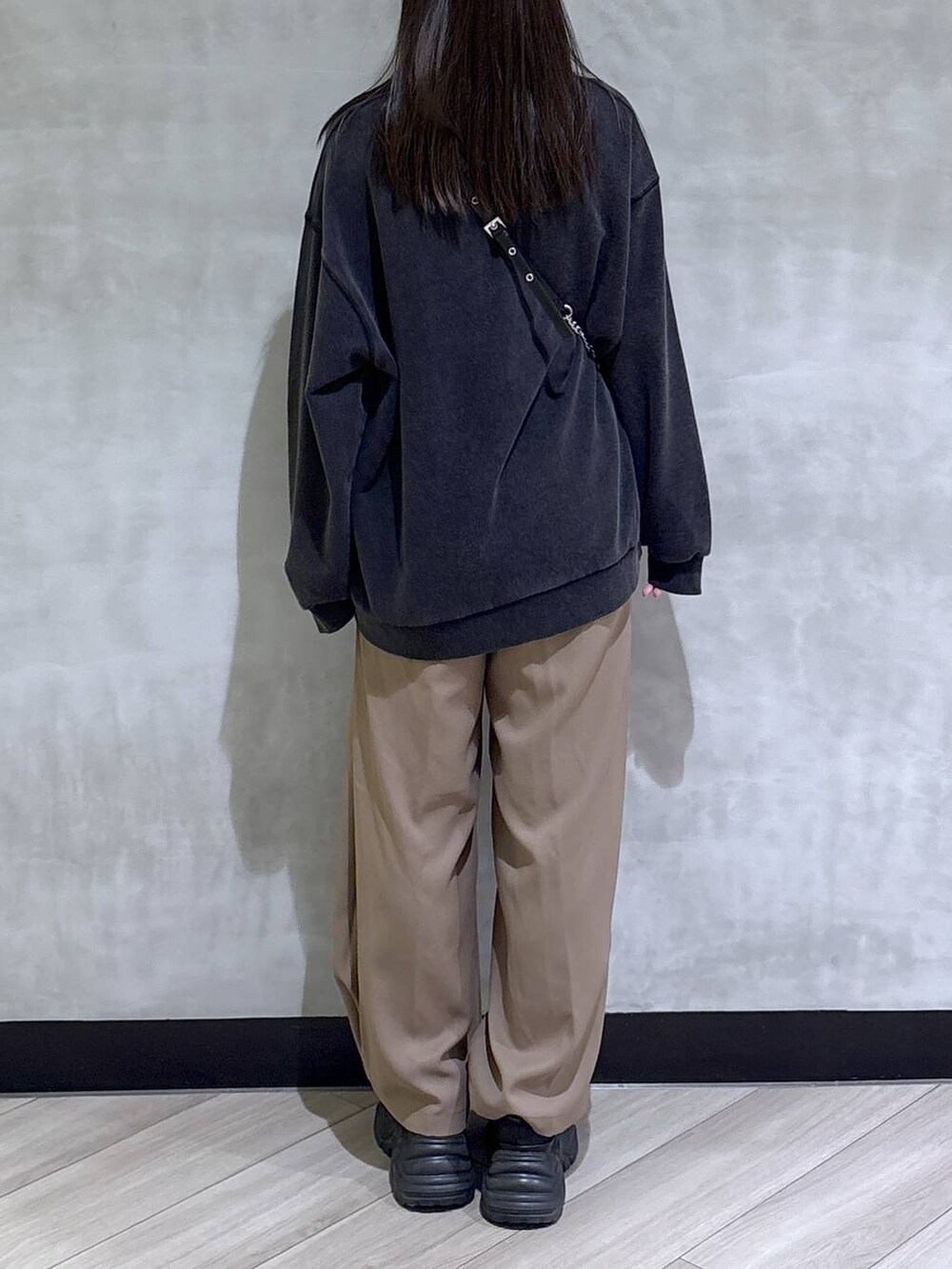 ブラック系のブーツ、グレー系のスウェット、ベージュ系のスラックスを着用したレディースの秋コーディネートの6枚目の写真