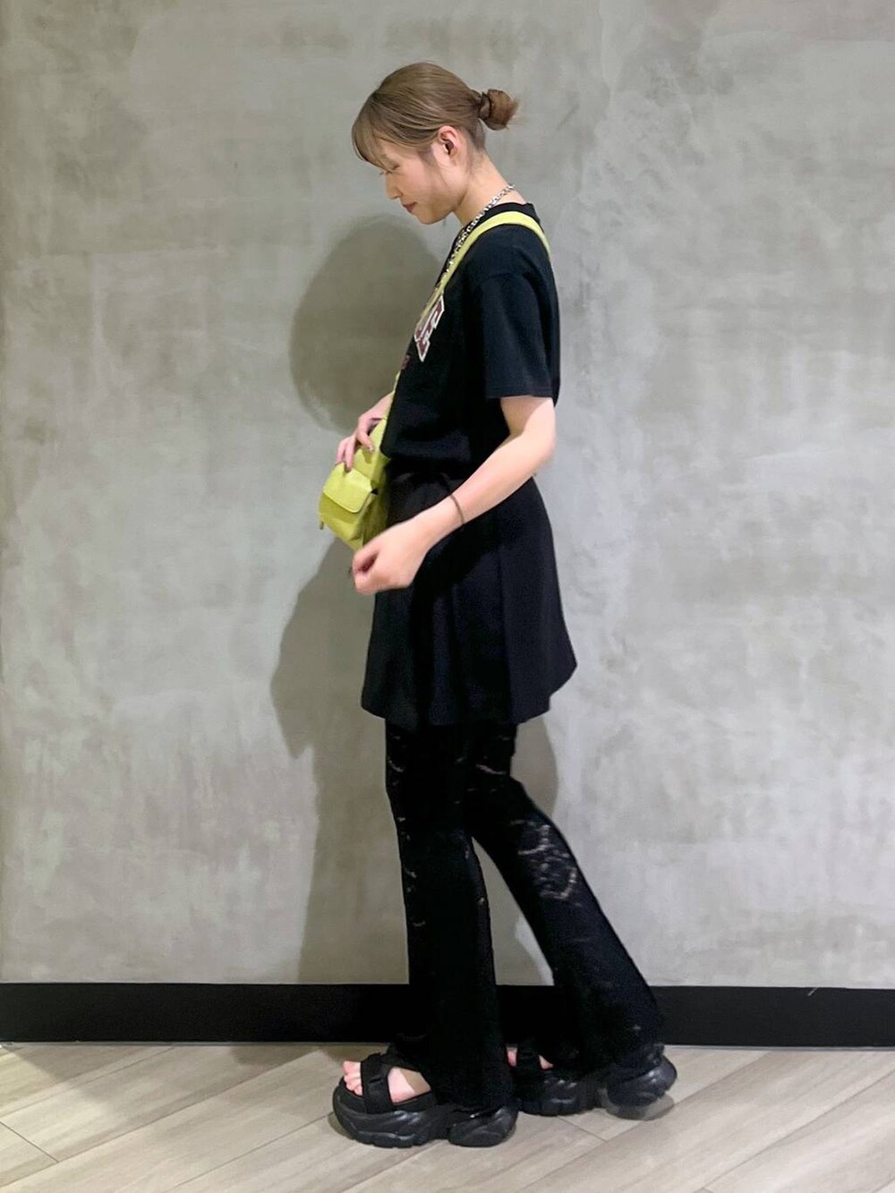 ブラック系のサンダル、ブラック系のスカート、グリーン系のショルダーバッグを着用したレディースの春コーディネートの4枚目の写真