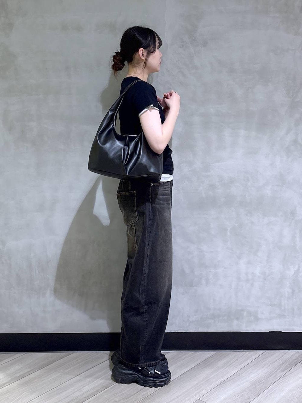 ブラック系のデニムパンツ、ブラック系のサンダル、ホワイト系のTシャツ/カットソーを着用したレディースの春コーディネートの6枚目の写真