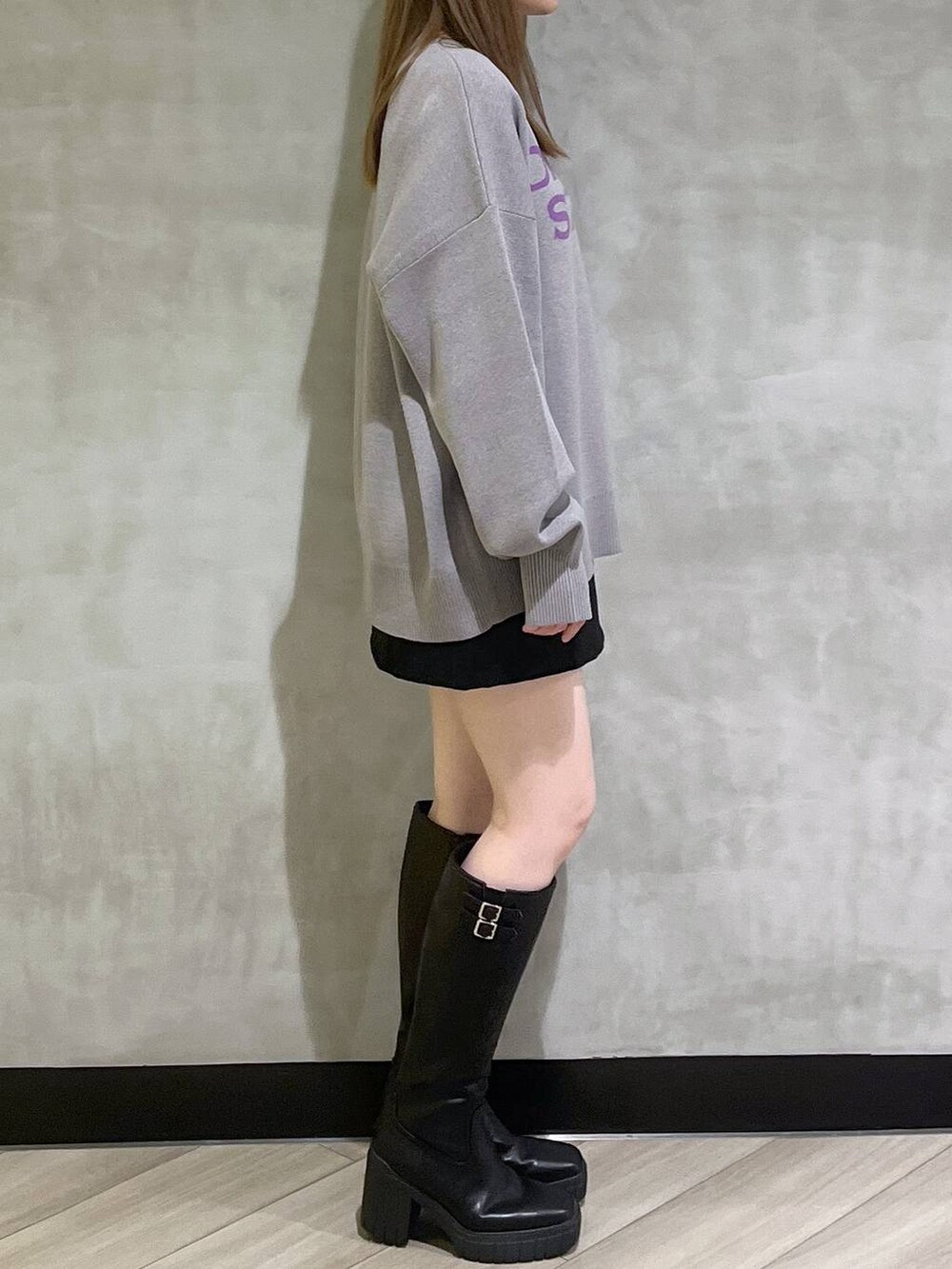 ブラック系のブーツ、ブラック系のスカート、グレー系のニット/セーターを着用したレディースの秋コーディネートの8枚目の写真