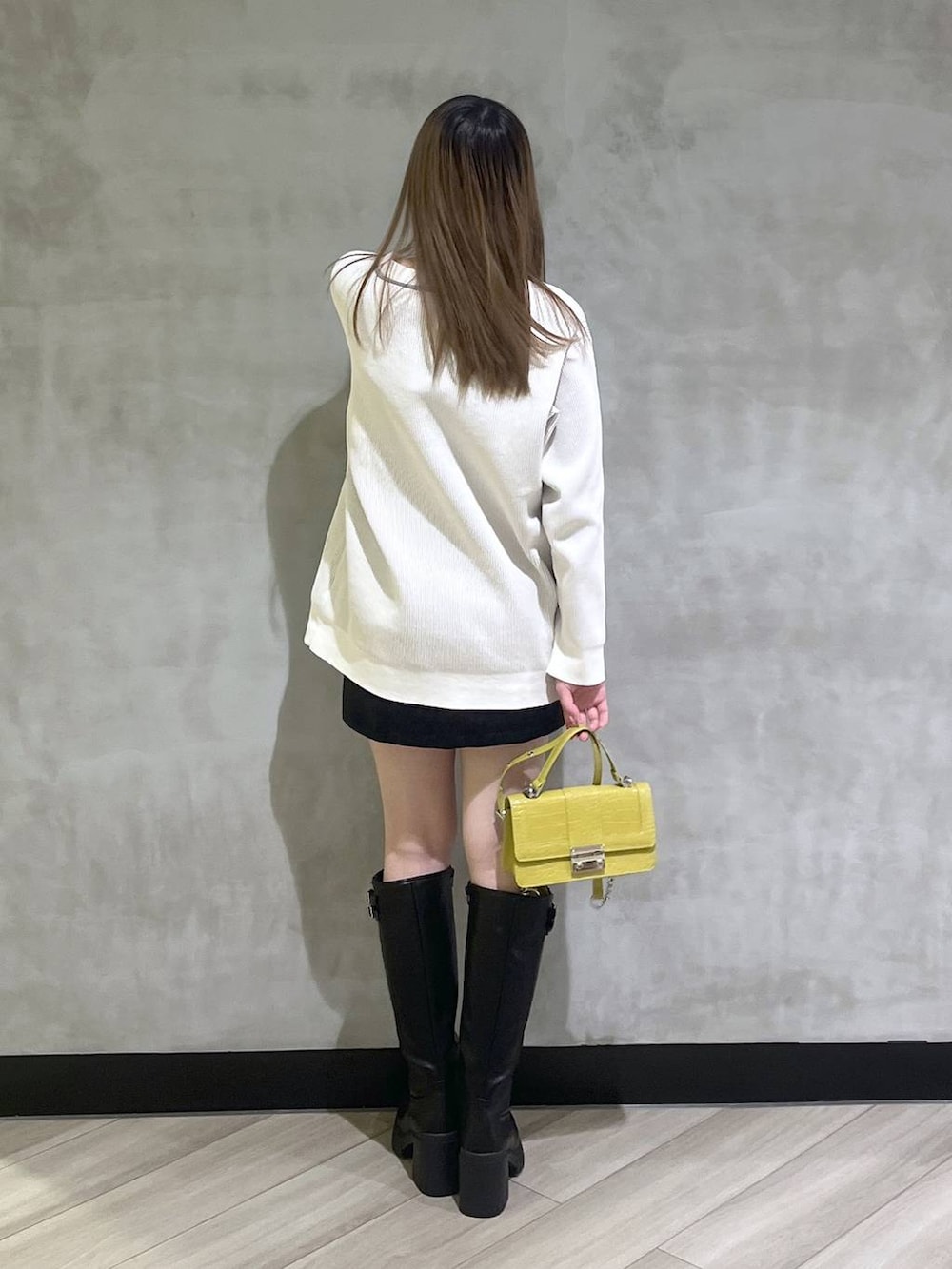 ブラック系のブーツ、ブラック系のスカート、ホワイト系のカーディガン/ボレロを着用したレディースの秋コーディネートの5枚目の写真