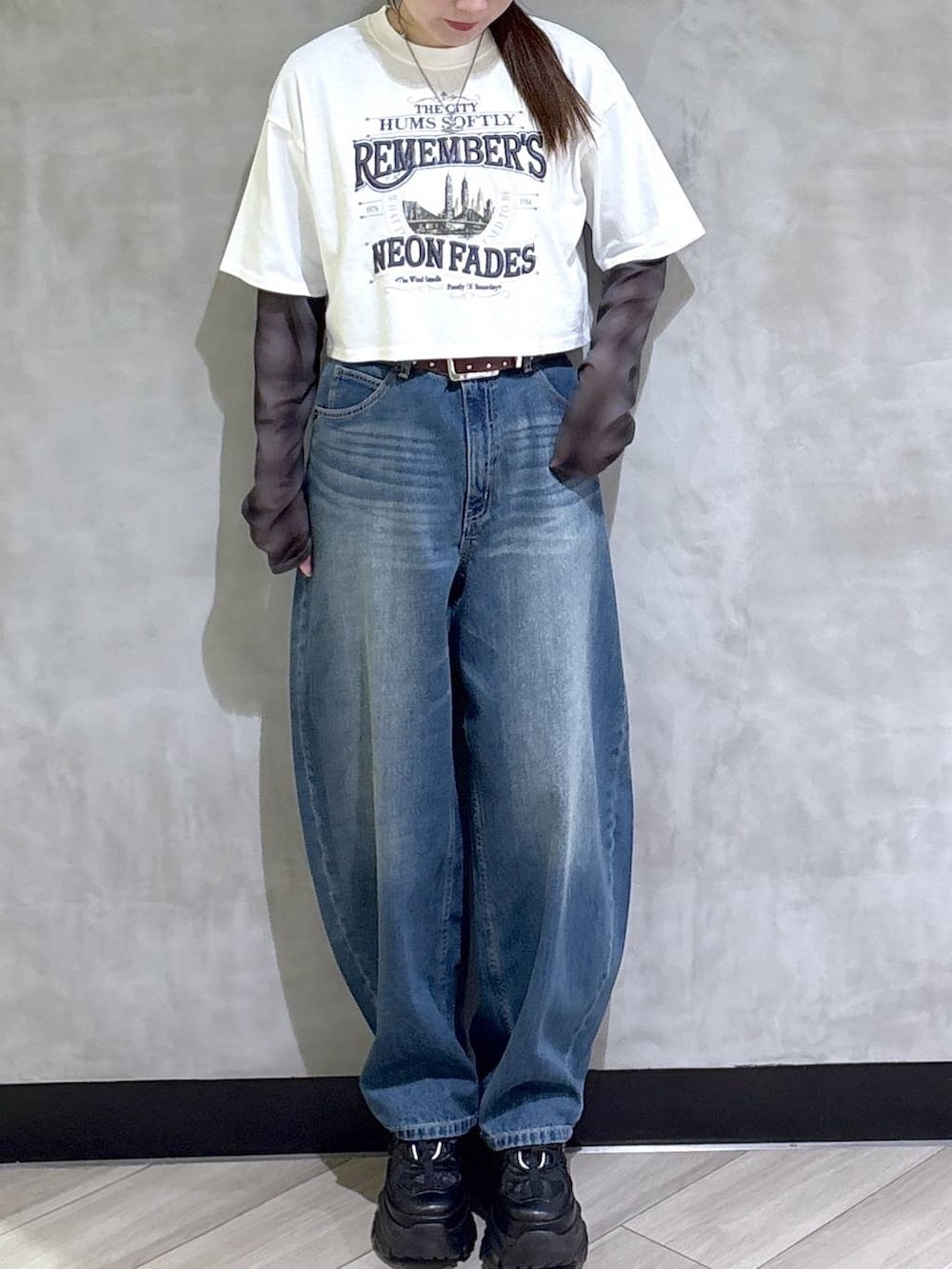 ブラック系のスニーカー、ホワイト系のTシャツ/カットソー、ブルー系のデニムパンツを着用したレディースの春コーディネートの2枚目の写真