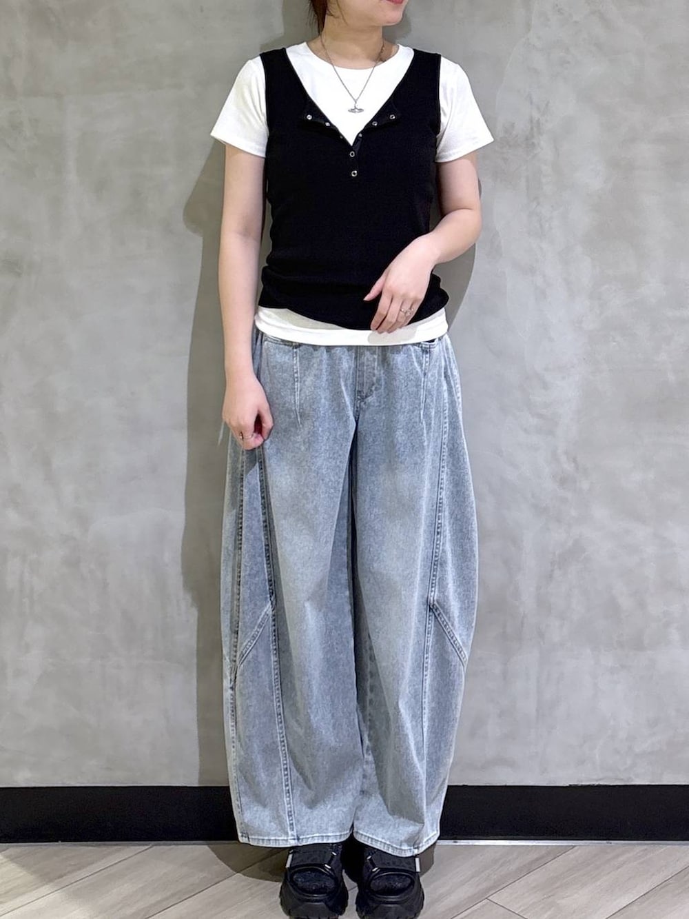 ブルー系のデニムパンツ、ブラック系のサンダル、ブラック系のタンクトップを着用したレディースの春コーディネートの2枚目の写真