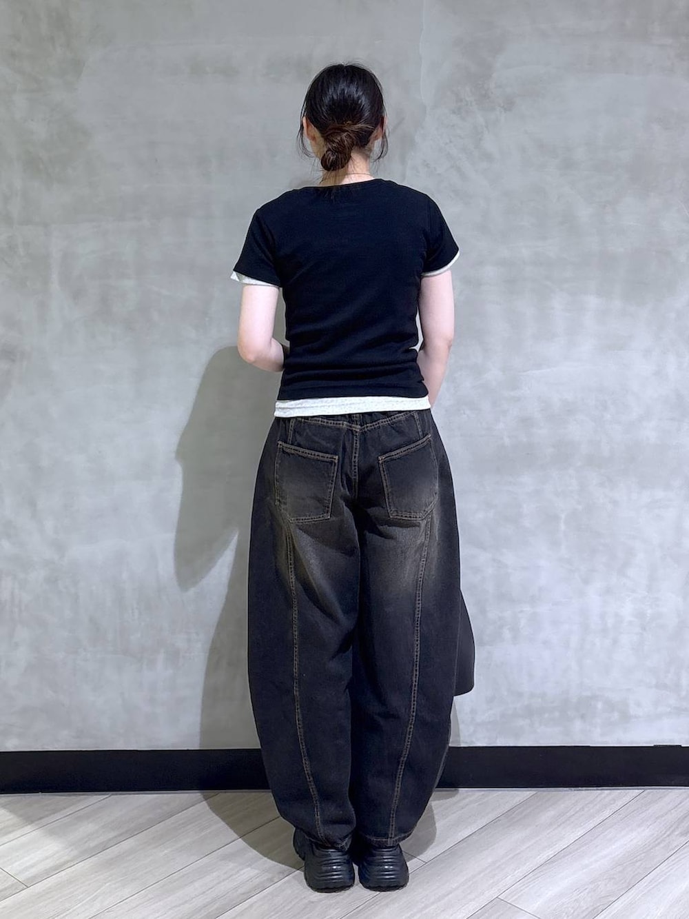 ブラック系のデニムパンツ、ブラック系のサンダル、ホワイト系のTシャツ/カットソーを着用したレディースの春コーディネートの5枚目の写真