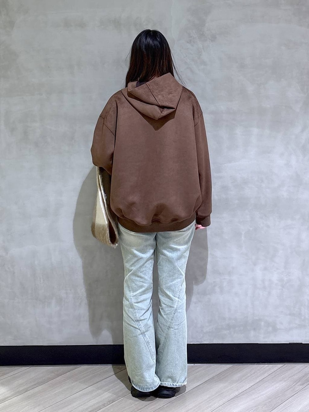 ブルー系のデニムパンツ、ブラック系のパーカー、ブラック系のローファーを着用したレディースの冬コーディネートの5枚目の写真