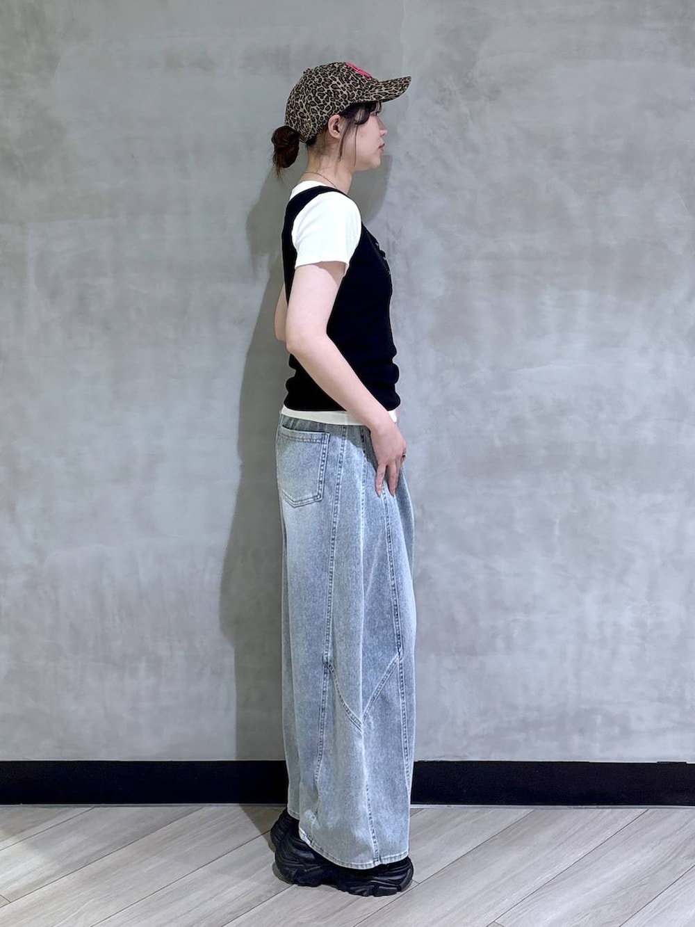ブルー系のデニムパンツ、ブラック系のサンダル、ブラック系のタンクトップを着用したレディースの春コーディネートの6枚目の写真