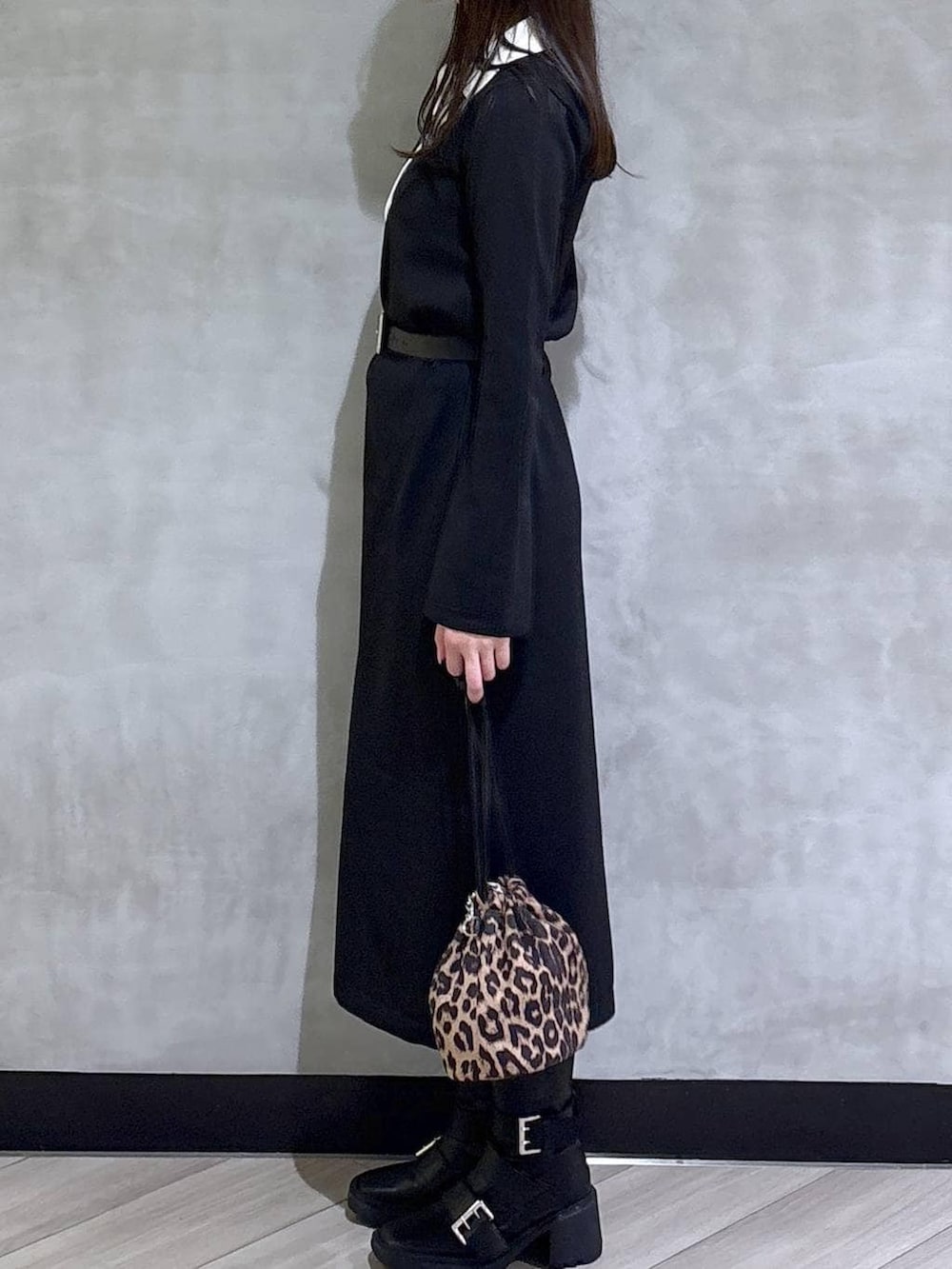 ブラック系のブーツ、ブラック系のワンピース、ブラック系のベルトを着用したレディースの秋コーディネートの4枚目の写真