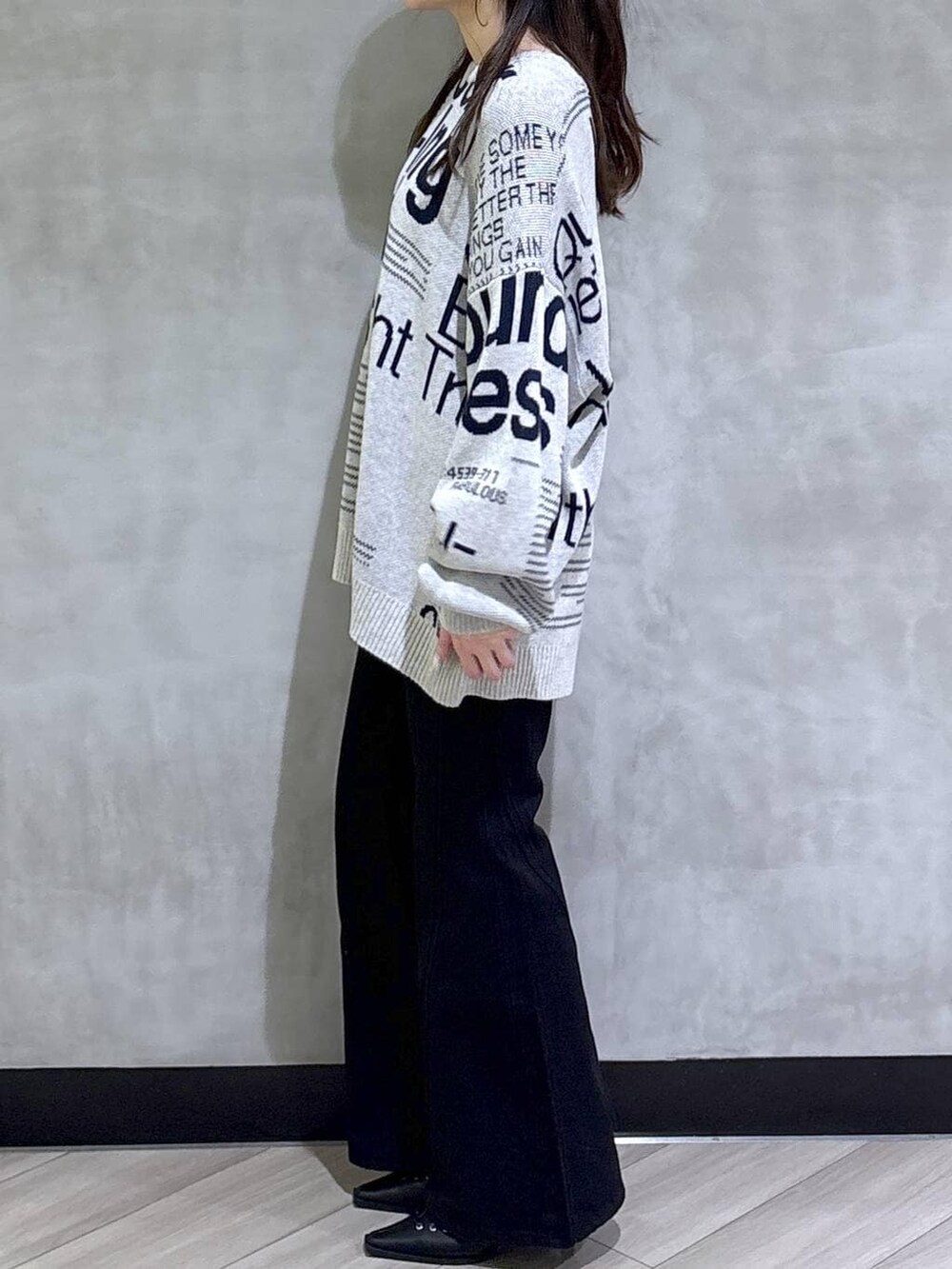 ブルー系のデニムパンツ、ブラック系のサンダル、グレー系のニット/セーターを着用したレディースの冬コーディネートの4枚目の写真