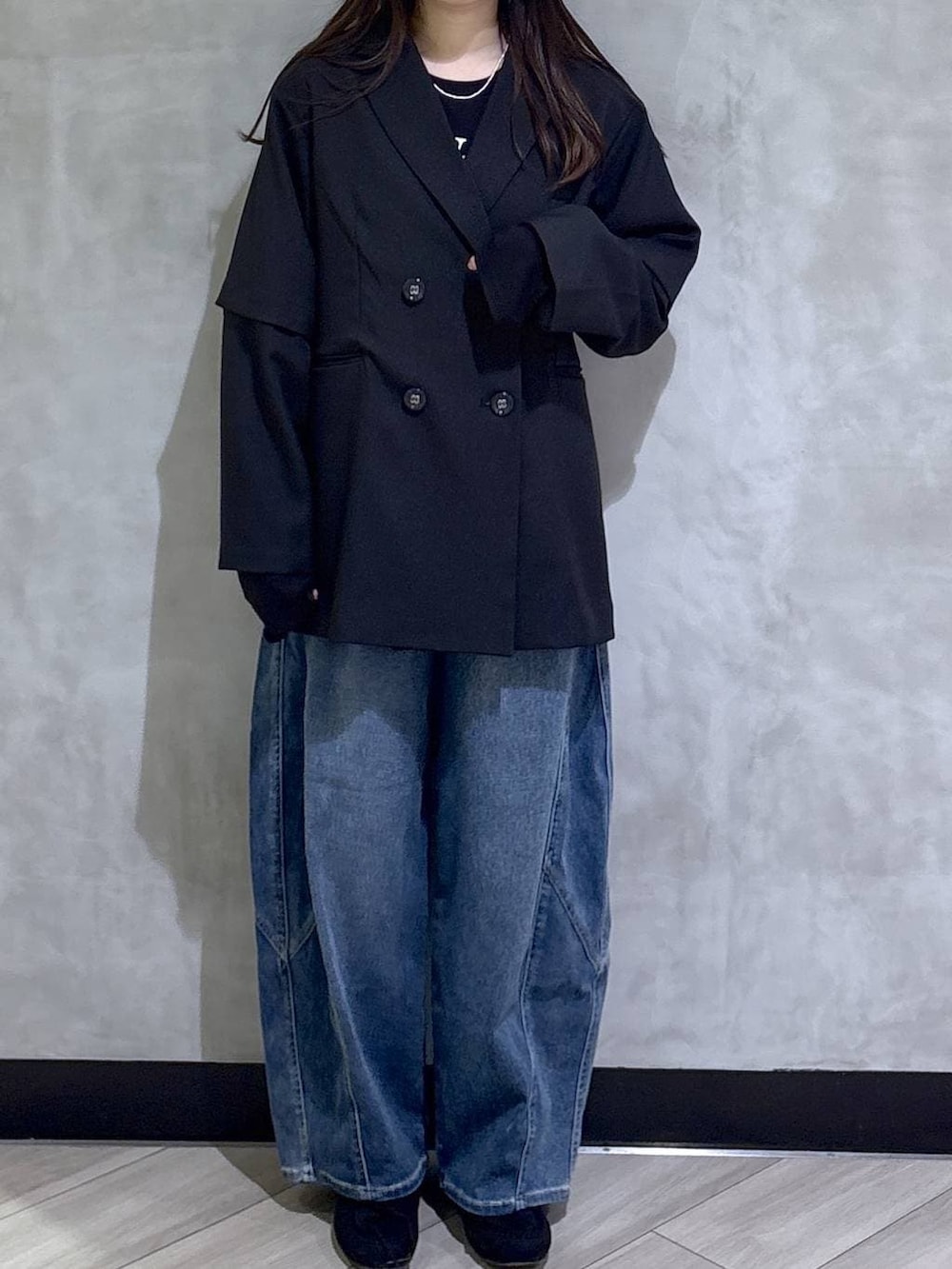 ブラック系のテーラードジャケット、ブルー系のデニムパンツ、ブラック系のモカシン/デッキシューズを着用したレディースの春コーディネートの2枚目の写真