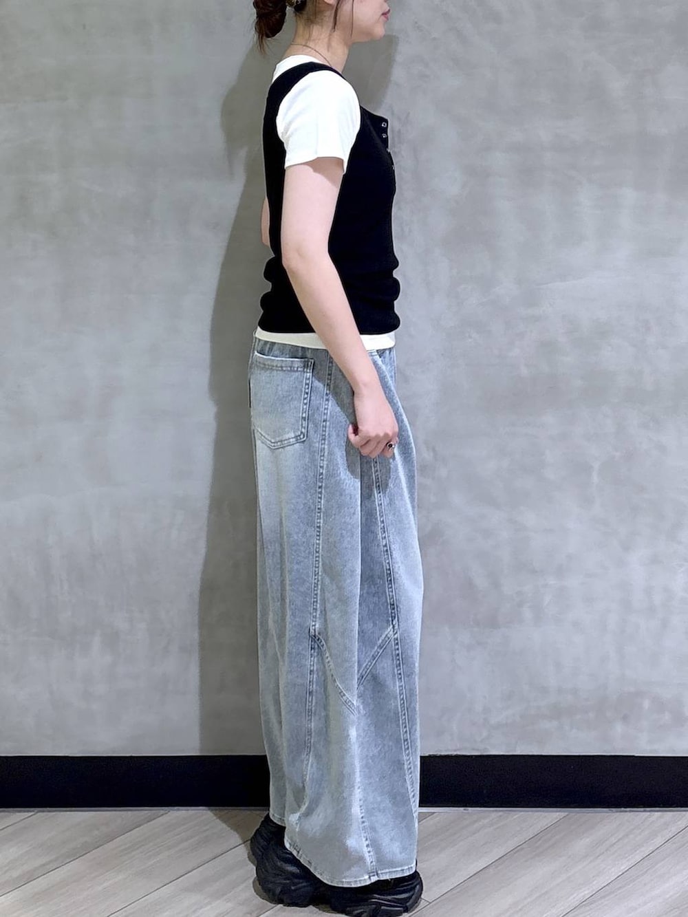 ブルー系のデニムパンツ、ブラック系のサンダル、ブラック系のタンクトップを着用したレディースの春コーディネートの7枚目の写真