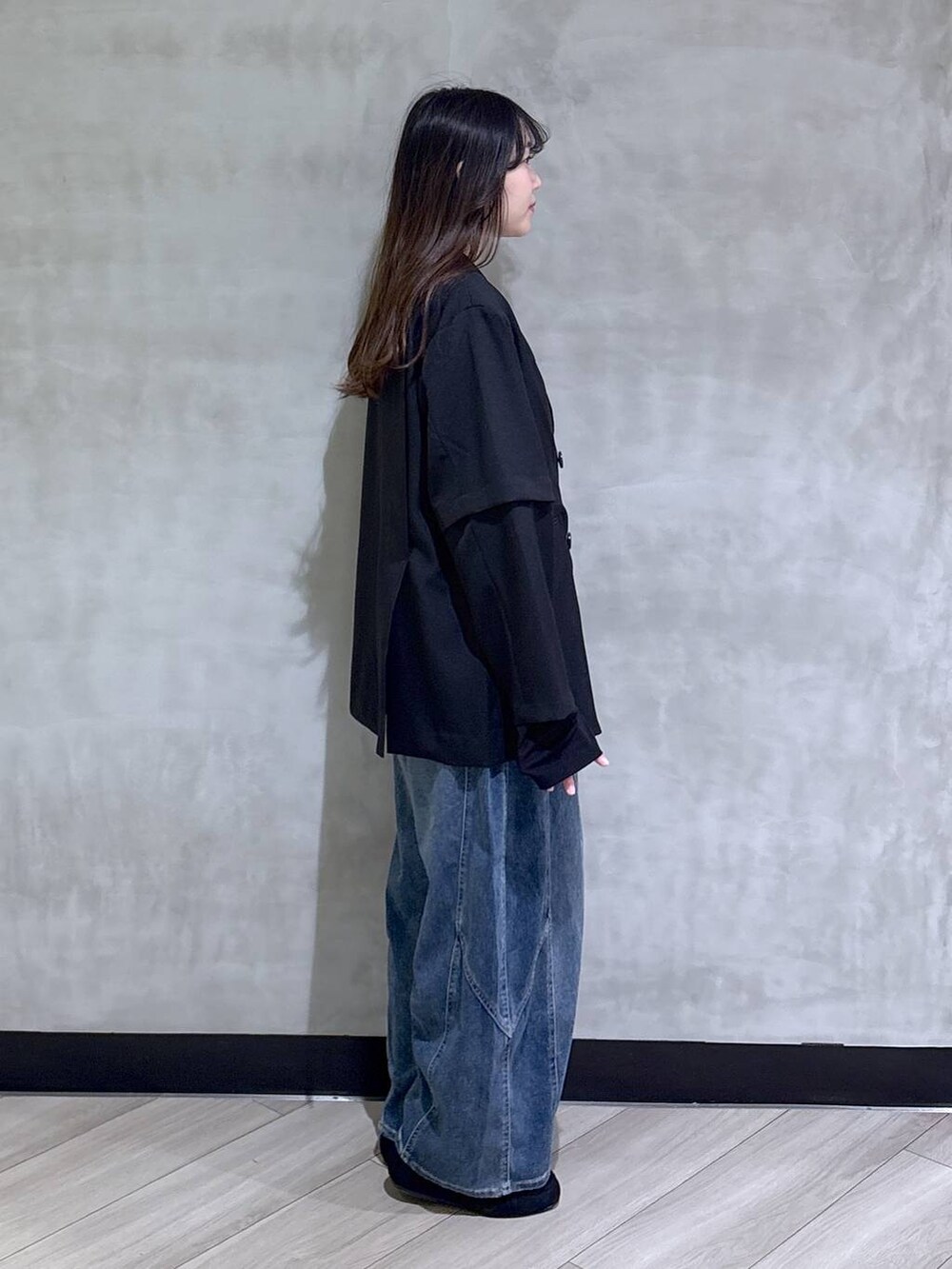 ブラック系のテーラードジャケット、ブルー系のデニムパンツ、ブラック系のモカシン/デッキシューズを着用したレディースの春コーディネートの6枚目の写真