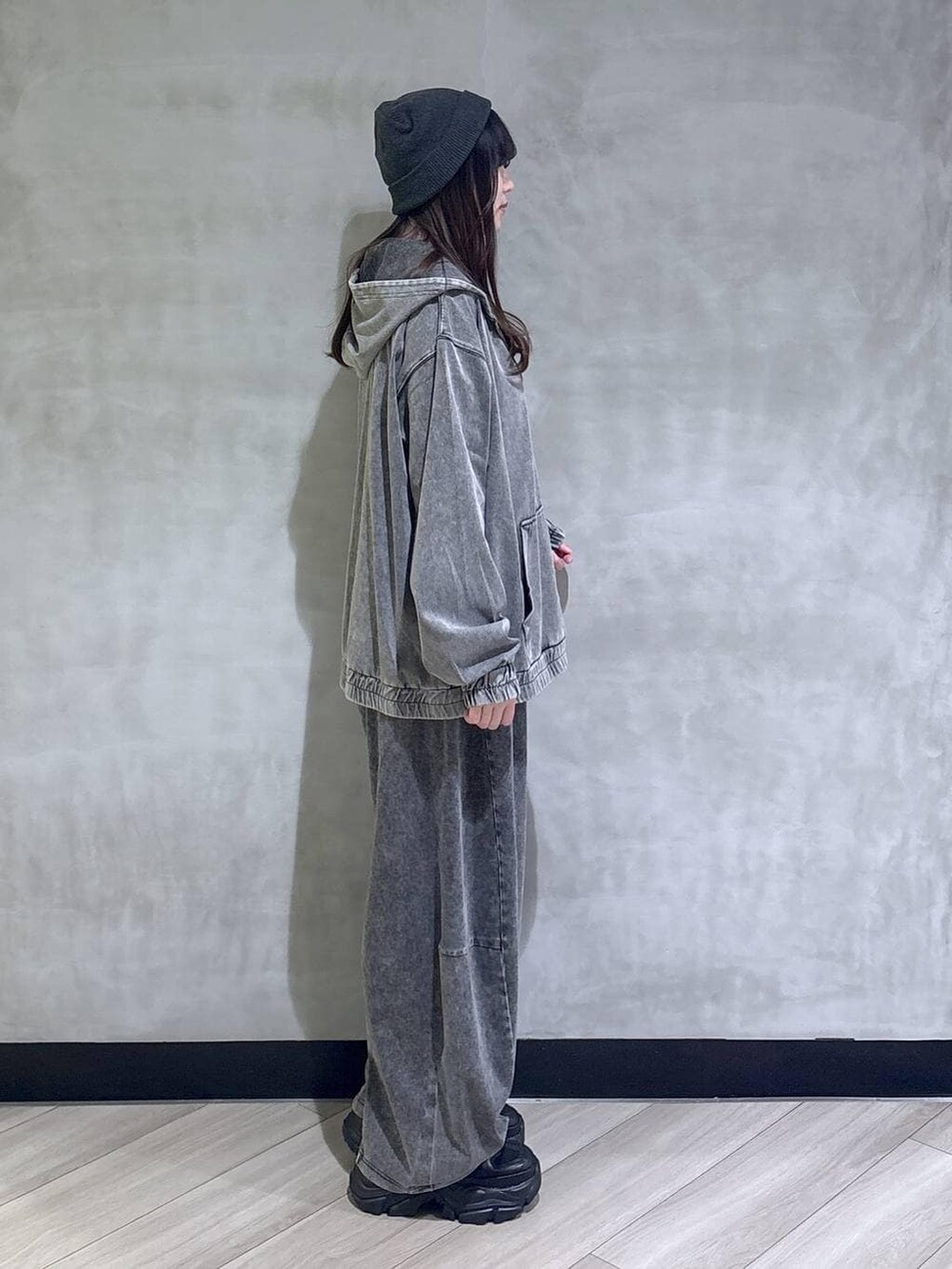 ブラック系のスニーカー、ブラック系のパーカー、ブラック系のデニムパンツを着用したレディースの春コーディネートの6枚目の写真