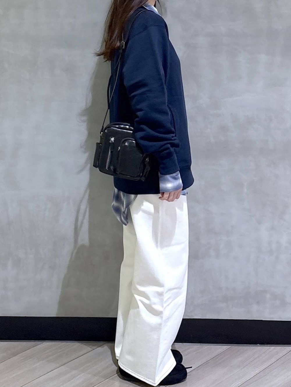 ブルー系のスウェット、ブルー系のスラックス、ブラック系のモカシン/デッキシューズを着用したレディースの春コーディネートの7枚目の写真