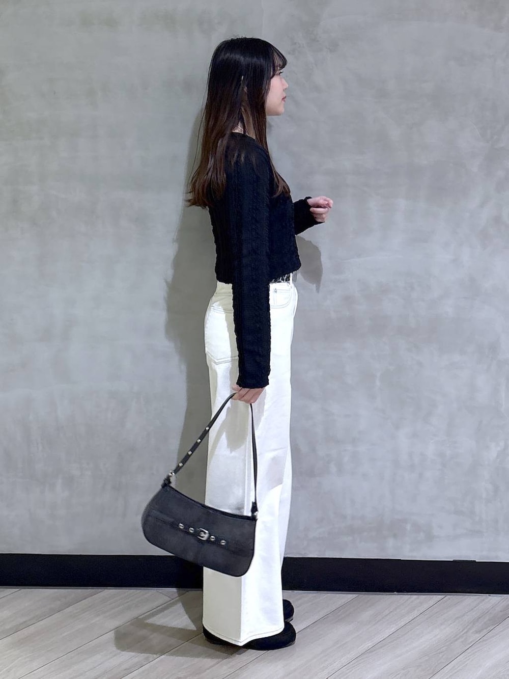 ブルー系のスラックス、ブラック系のハンドバッグ、ブラック系のモカシン/デッキシューズを着用したレディースの春コーディネートの6枚目の写真