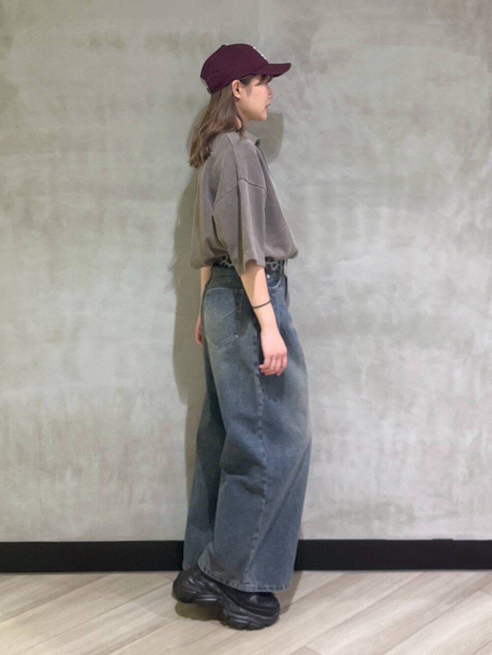 ブルー系のデニムパンツ、ブラウン系のスウェット、シルバー系のスニーカーを着用したレディースの夏コーディネートの6枚目の写真