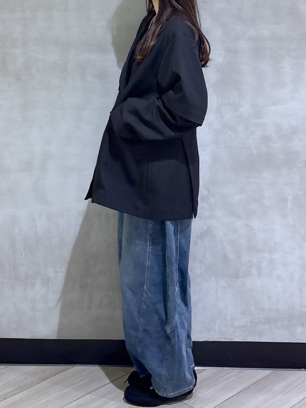 ブラック系のテーラードジャケット、ブルー系のデニムパンツ、ブラック系のモカシン/デッキシューズを着用したレディースの春コーディネートの4枚目の写真