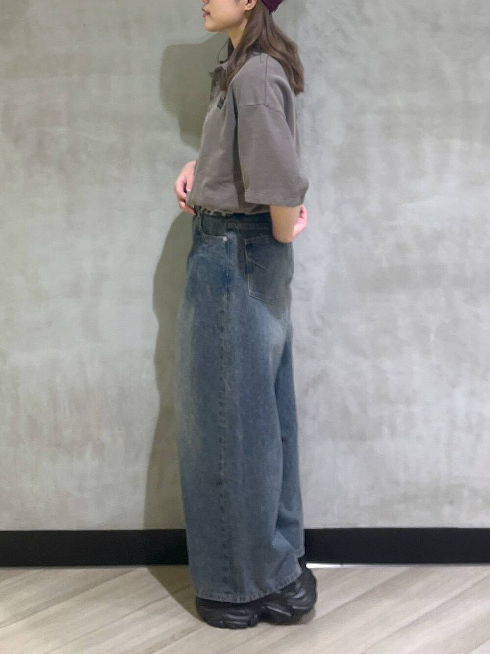 ブルー系のデニムパンツ、ブラウン系のスウェット、シルバー系のスニーカーを着用したレディースの夏コーディネートの3枚目の写真