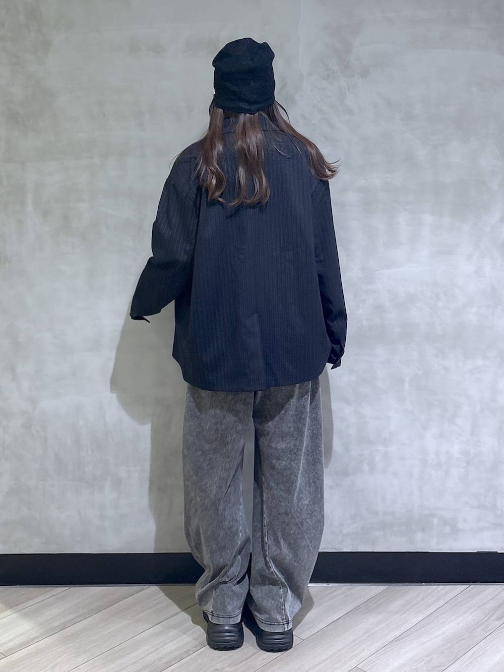 ブラック系のスニーカー、ブラック系のデニムパンツ、ブルー系のテーラードジャケットを着用したレディースの春コーディネートの5枚目の写真