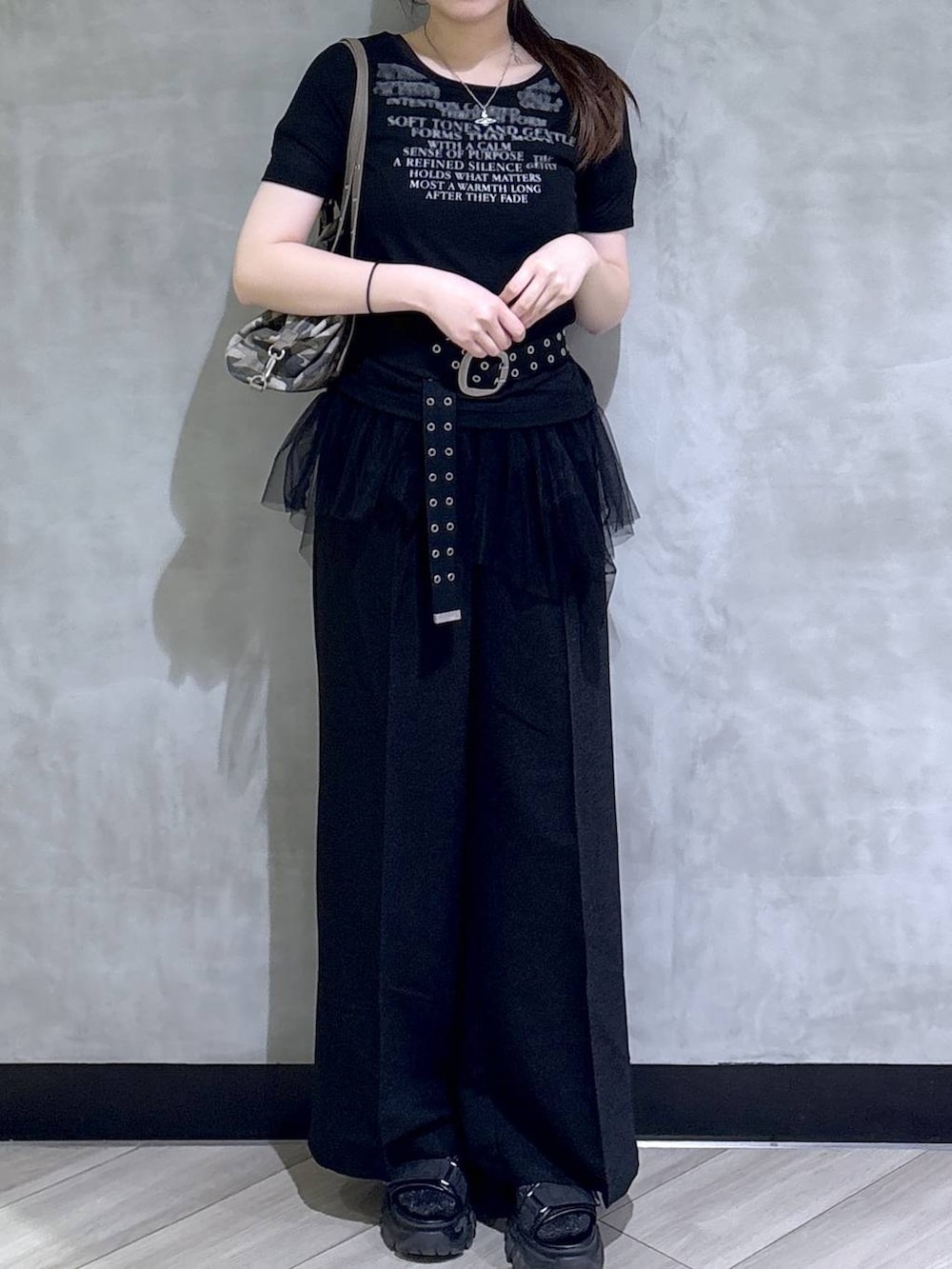 グレー系のサンダル、ブラック系のスラックス、ブラック系のTシャツ/カットソーを着用したレディースの春コーディネートの2枚目の写真