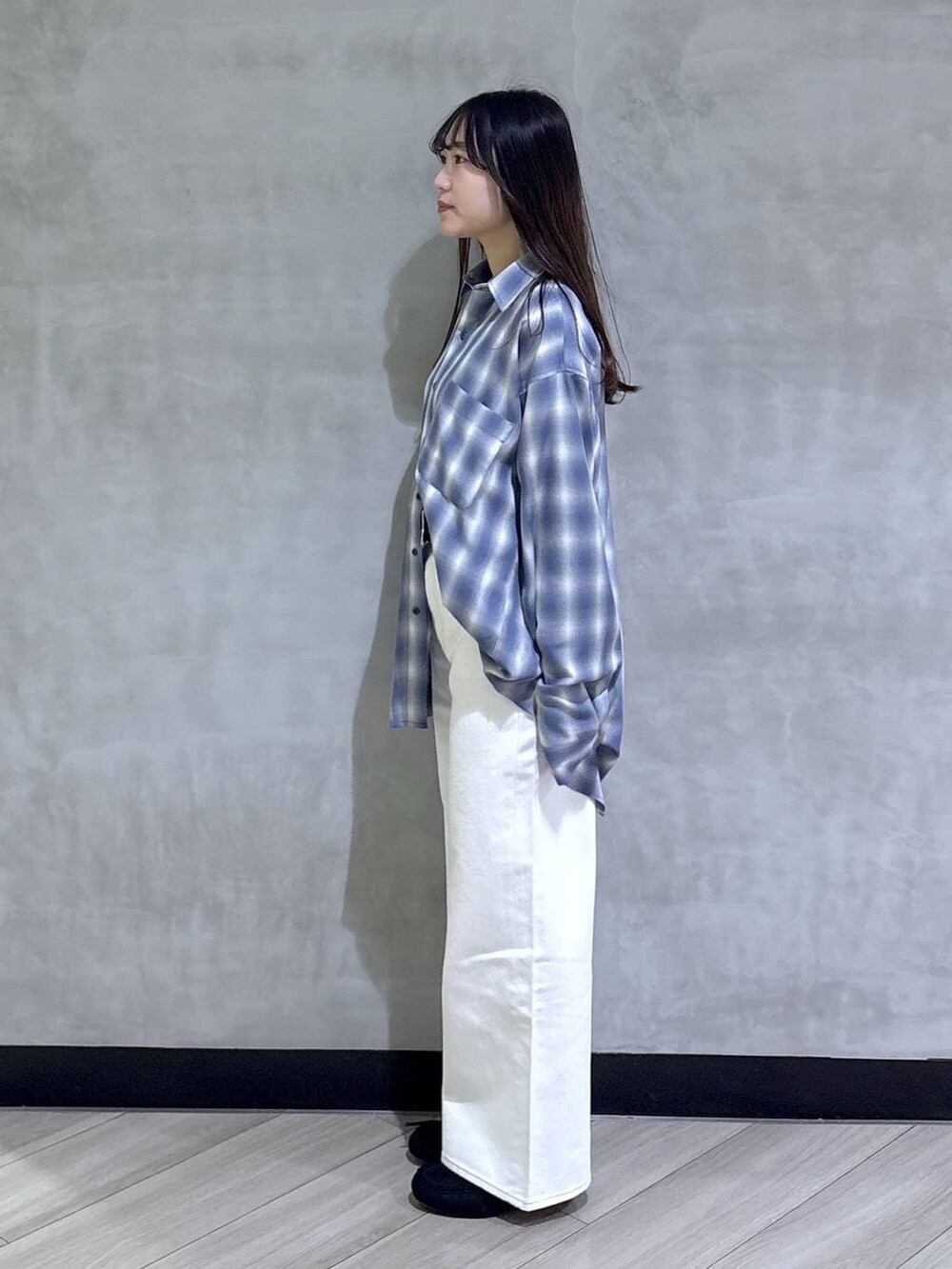ホワイト系のデニムパンツ、ブラック系のモカシン/デッキシューズ、ブルー系のシャツ/ブラウスを着用したレディースの春コーディネートの3枚目の写真