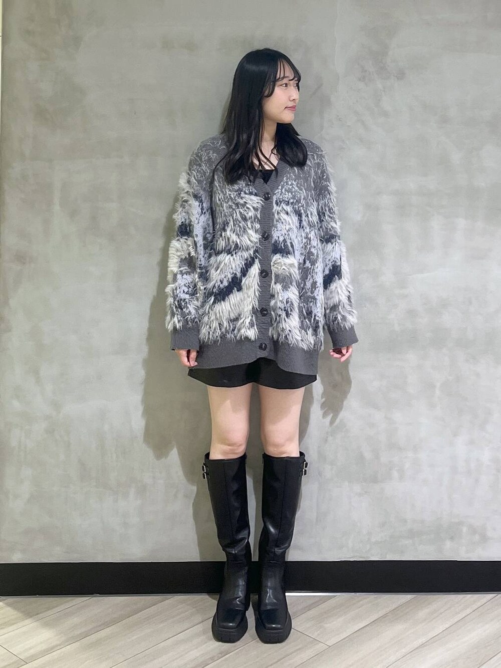 ブラック系のブーツ、グレー系のカーディガン/ボレロ、ブラック系のその他パンツを着用したレディースの秋コーディネートの2枚目の写真