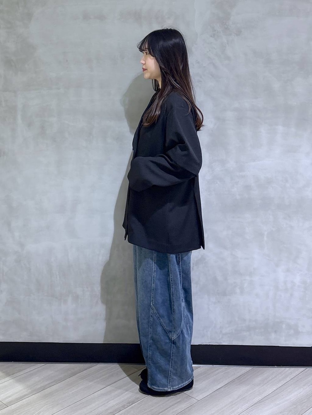 ブラック系のテーラードジャケット、ブルー系のデニムパンツ、ブラック系のモカシン/デッキシューズを着用したレディースの春コーディネートの3枚目の写真