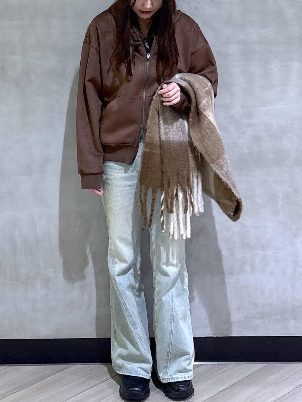 ブルー系のデニムパンツ、ブラック系のパーカー、ブラック系のローファーを着用したレディースの冬コーディネートの2枚目の写真