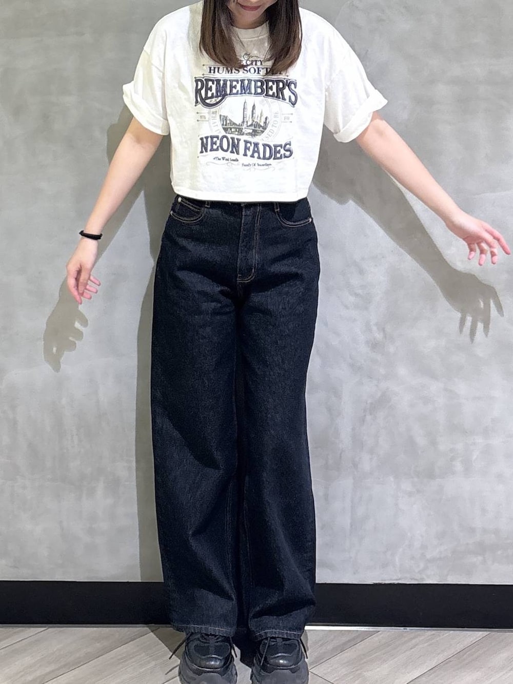 ブラック系のスニーカー、ブルー系のデニムパンツ、ホワイト系のTシャツ/カットソーを着用したレディースの夏コーディネートの2枚目の写真