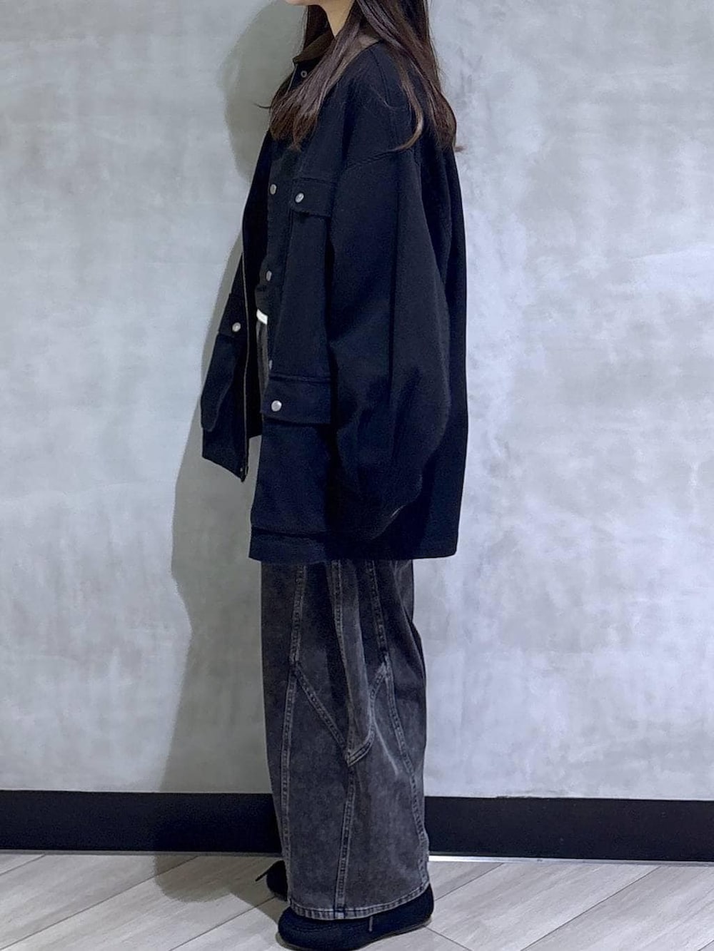 ブラック系のデニムパンツ、ブラック系のモカシン/デッキシューズ、ブラック系のその他アウターを着用したレディースの春コーディネートの4枚目の写真