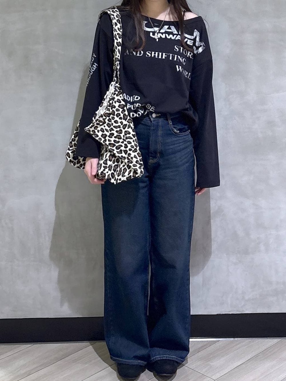 ブルー系のスラックス、ブラック系のモカシン/デッキシューズ、ブラック系のTシャツ/カットソーを着用したレディースの冬コーディネートの2枚目の写真