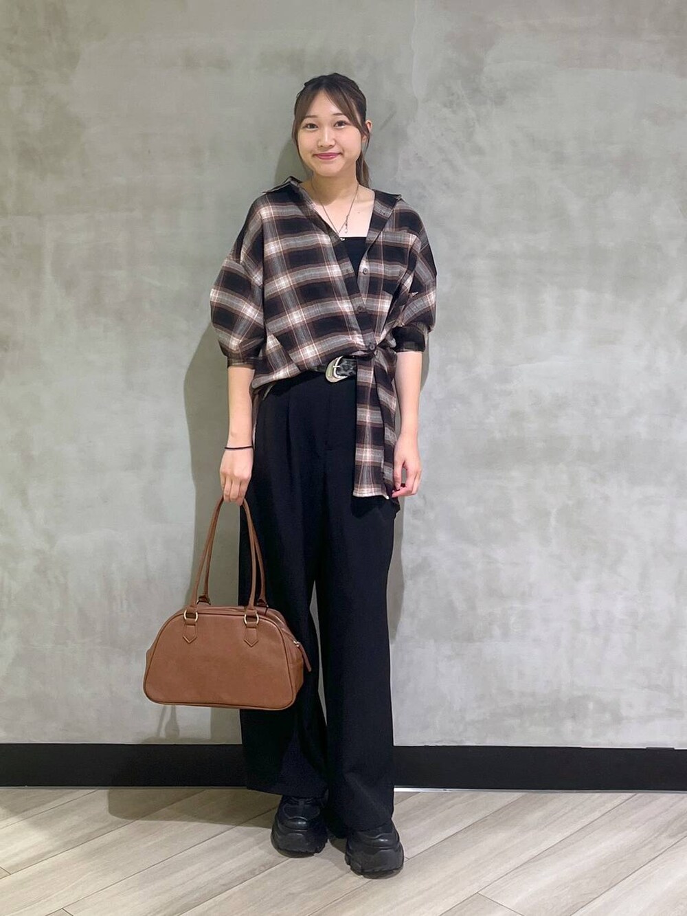 ブラック系のスニーカー、ブラック系のスラックス、ブラウン系のシャツ/ブラウスを着用したレディースの秋コーディネートの3枚目の写真