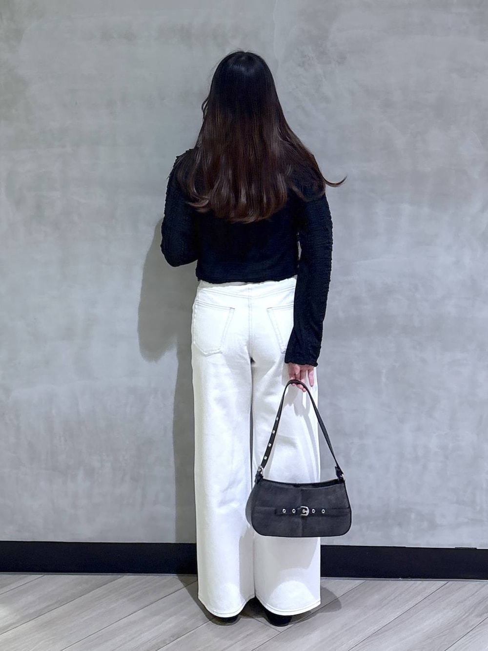 ブルー系のスラックス、ブラック系のハンドバッグ、ブラック系のモカシン/デッキシューズを着用したレディースの春コーディネートの5枚目の写真