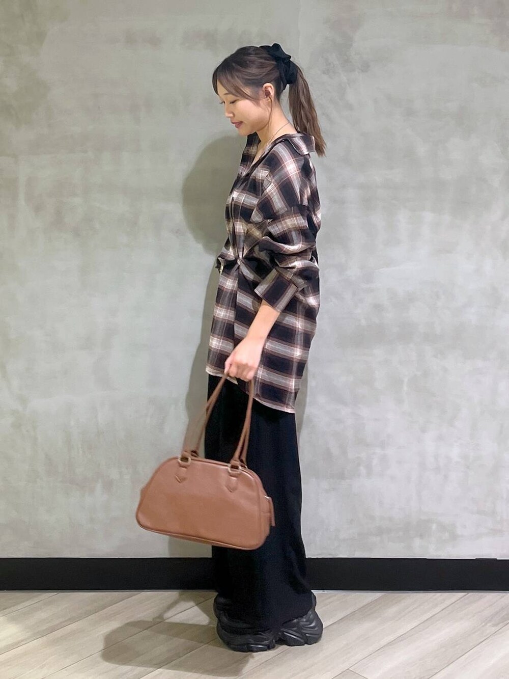 ブラック系のスニーカー、ブラック系のスラックス、ブラウン系のシャツ/ブラウスを着用したレディースの秋コーディネートの4枚目の写真