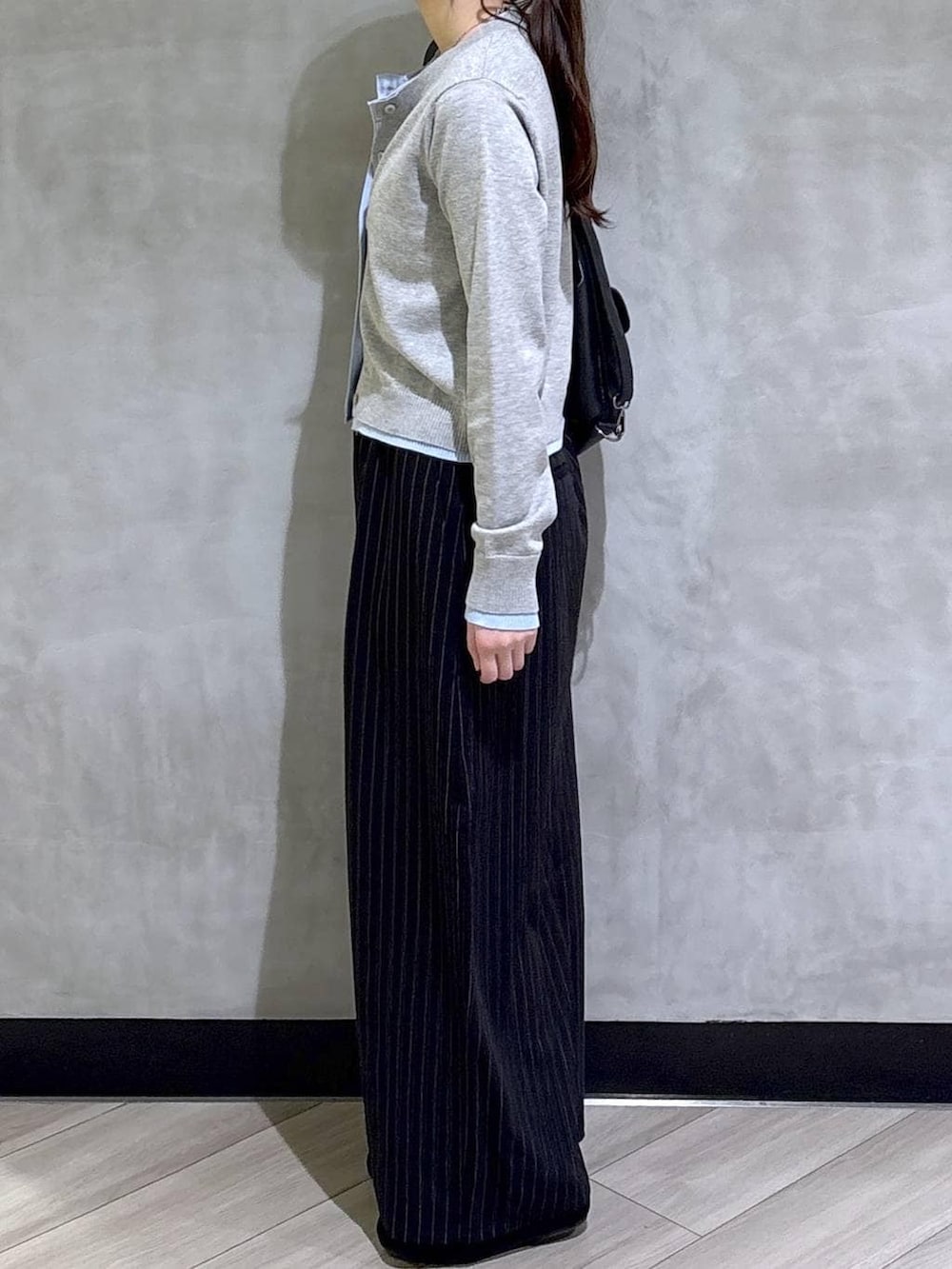 ブラック系のスラックス、グレー系のカーディガン/ボレロ、ブラック系のモカシン/デッキシューズを着用したレディースの春コーディネートの8枚目の写真