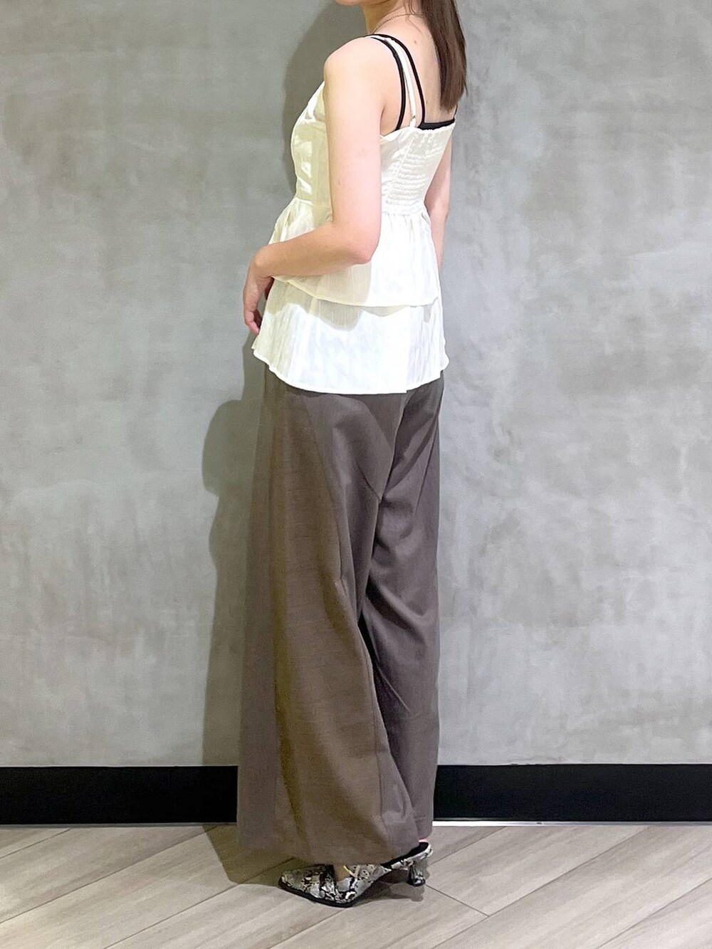 ホワイト系のパンプス、ブラウン系のスラックス、ホワイト系のキャミソールを着用したレディースの夏コーディネートの8枚目の写真