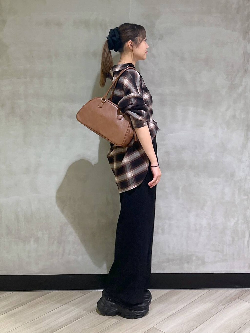 ブラック系のスニーカー、ブラック系のスラックス、ブラウン系のシャツ/ブラウスを着用したレディースの秋コーディネートの9枚目の写真