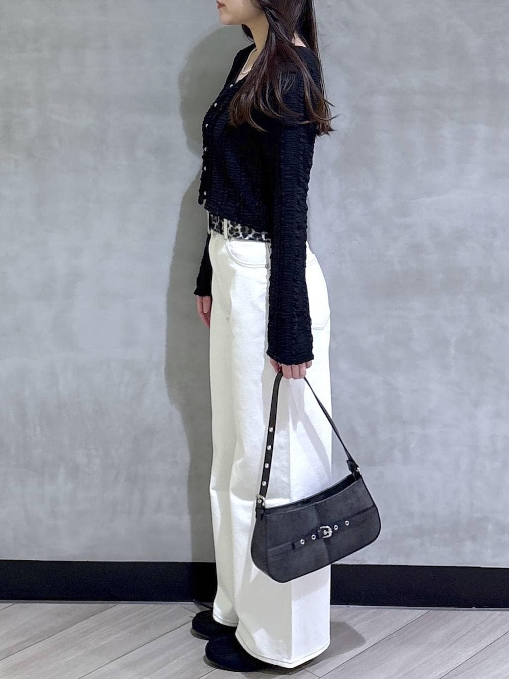 ブルー系のスラックス、ブラック系のハンドバッグ、ブラック系のモカシン/デッキシューズを着用したレディースの春コーディネートの4枚目の写真