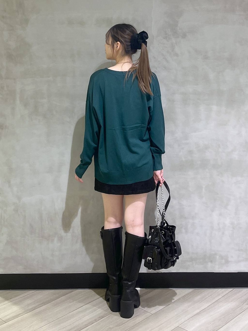 ブラック系のブーツ、ブラック系のスカート、グリーン系のカーディガン/ボレロを着用したレディースの秋コーディネートの5枚目の写真