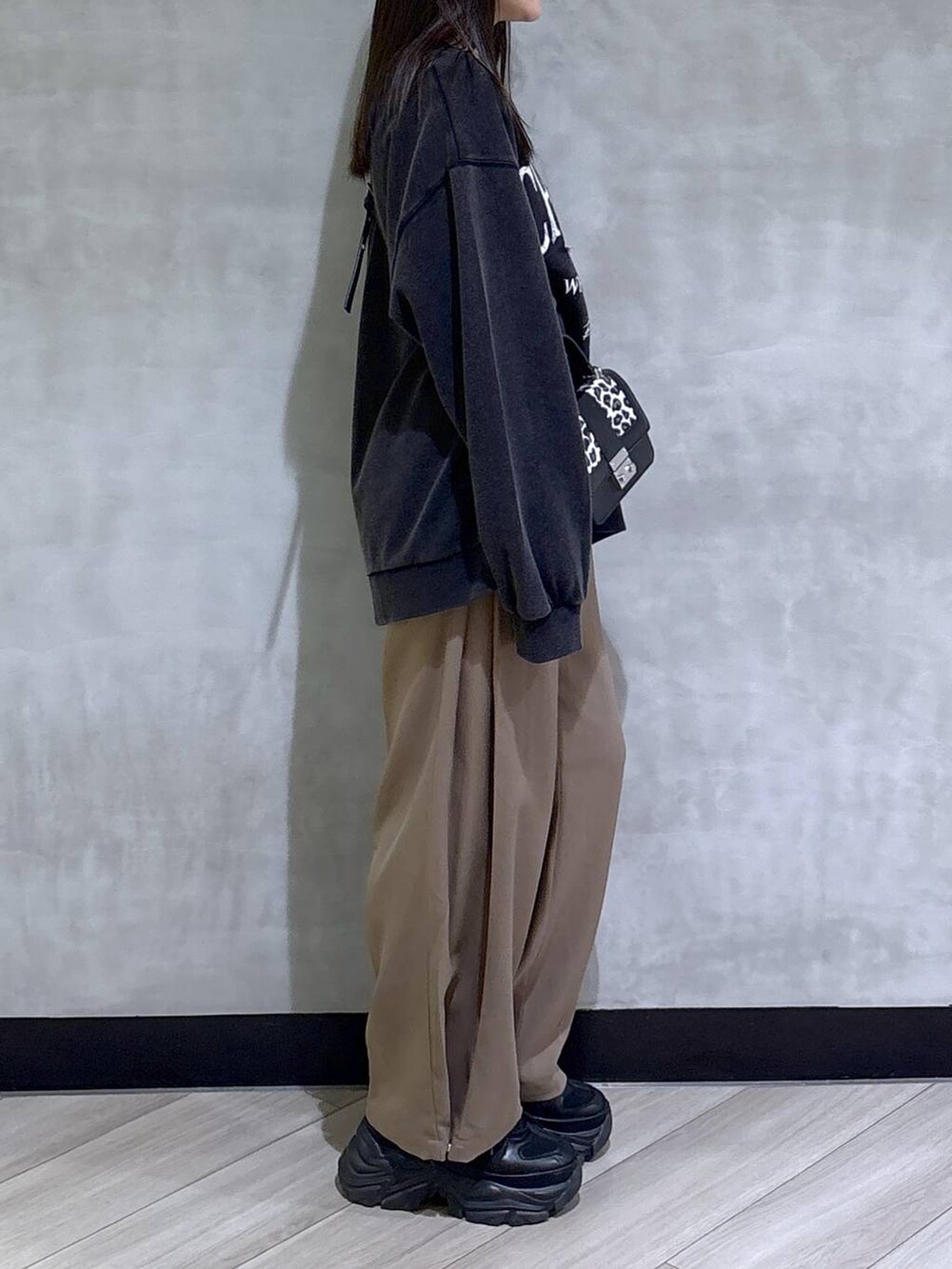 ブラック系のブーツ、グレー系のスウェット、ベージュ系のスラックスを着用したレディースの秋コーディネートの8枚目の写真