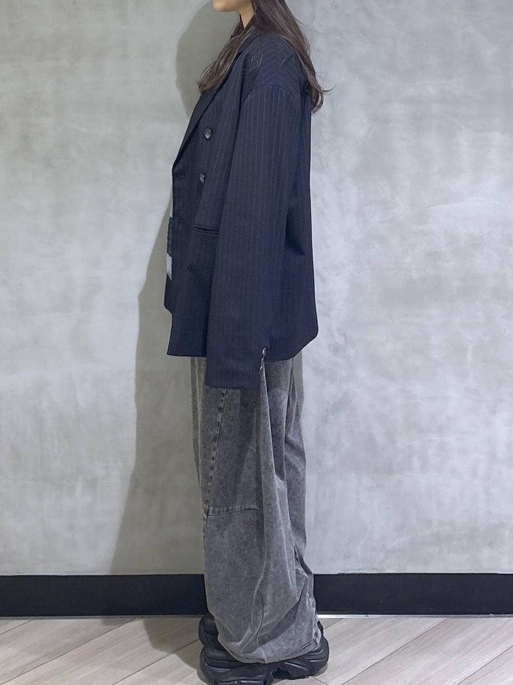 ブラック系のスニーカー、ブラック系のデニムパンツ、ブルー系のテーラードジャケットを着用したレディースの春コーディネートの4枚目の写真