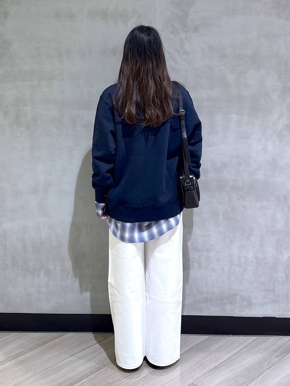 ブルー系のスウェット、ブルー系のスラックス、ブラック系のモカシン/デッキシューズを着用したレディースの春コーディネートの5枚目の写真