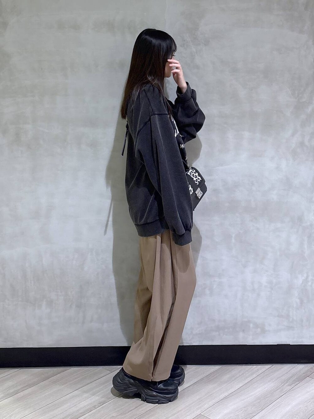 ブラック系のブーツ、グレー系のスウェット、ベージュ系のスラックスを着用したレディースの秋コーディネートの7枚目の写真